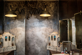 Ванная комната, стилизованная под лофт из фильма ужасов, в которой стены глазированы перламутровым лаком. Кукольный дом призван смягчить эффект.