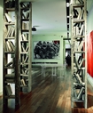 На переднем плане: инсталляция Петра Белого «Библиотека Пиноккио», созданная из разобранных полов коммунальных квартир. В центре комнаты: работа Анны