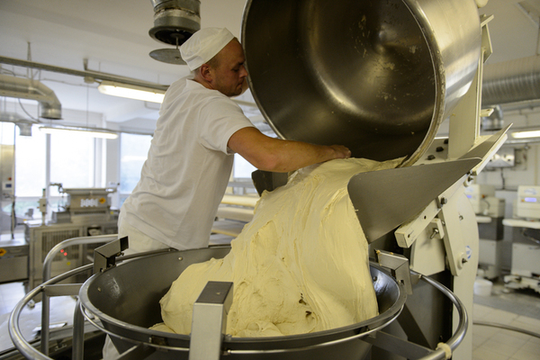 Тесто из большого котла переливается на разделочную линию