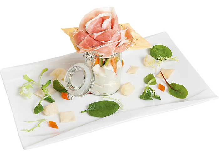 Цветок из пармына чипсе из крекера с льняными семечками, муссом из цветной капусты, овощами и листьями салата