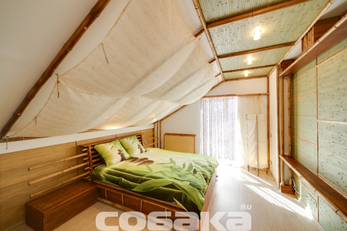 Парусиновые драпировки на потолке, лампы, свет которых приглушен циновками, ротанговая мебель и спрятанные за необычными бамбуковыми экранами батареи