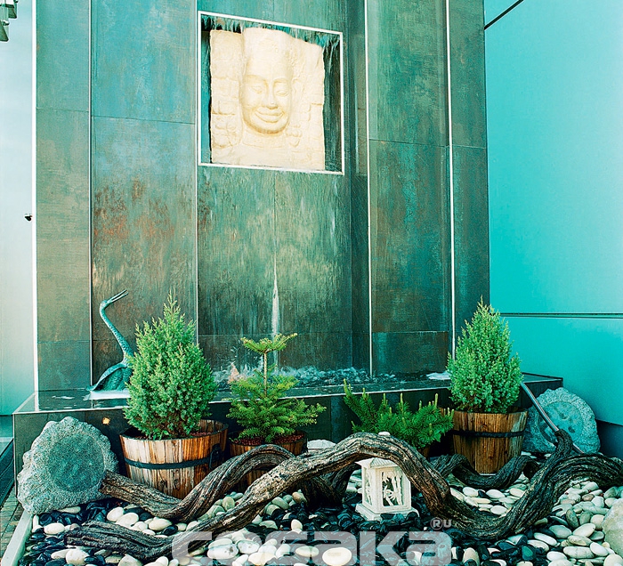 Восточный фонтан украшен композицией из дерева и камней