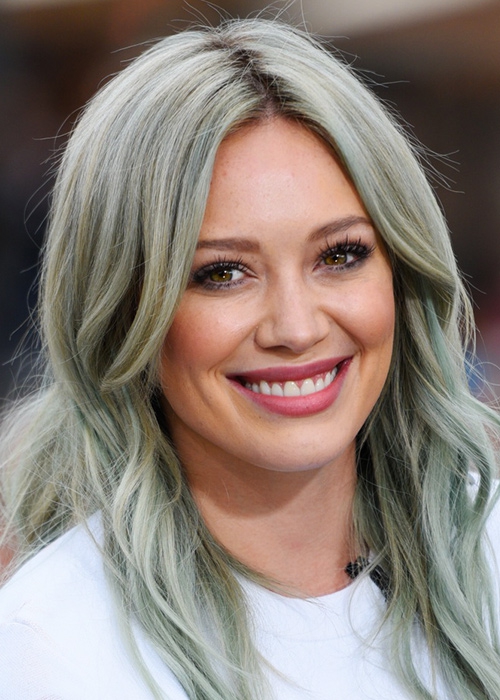 Хилари Дафф случайно попала в тренд на седые волосы, когда с ее платинового блонда стало постепенно смываться зеленое тонирование, сделанное ей на