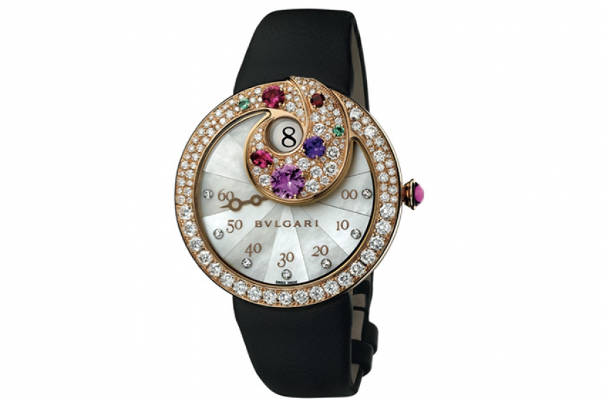 Bvlgari Berries Внутри улитки из розового золота, покрытой сапфирами, рубинами и изумрудами, кроется окошко «прыгающего часа». А по перламутровой