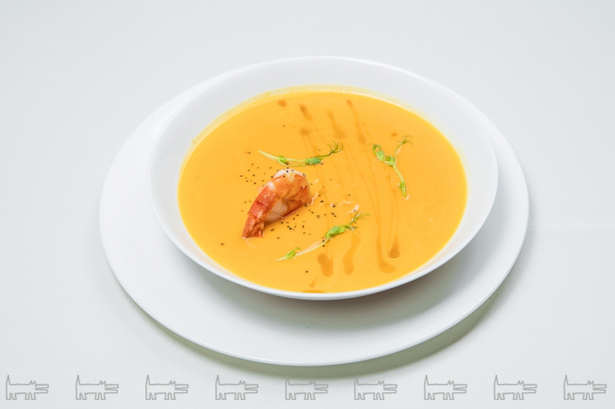 Крем-суп из тыквыЛегкий крем-суп с жареной креветкой и ростками молодого горошка.