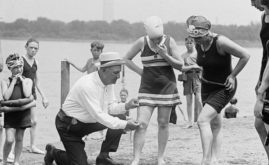 Член «Отряда морали» проверяет длину купальника девушек\