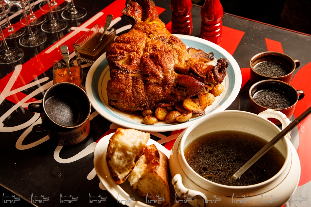 Половина головы свиньи, подается с запеченным картофелем и капустой, бульоном и домашним хлебом