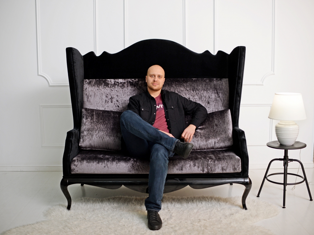 Станислав Коргунюк, директор фабрики «Авторский проект» на диване, выполненном по проекту Кати Камбаровой