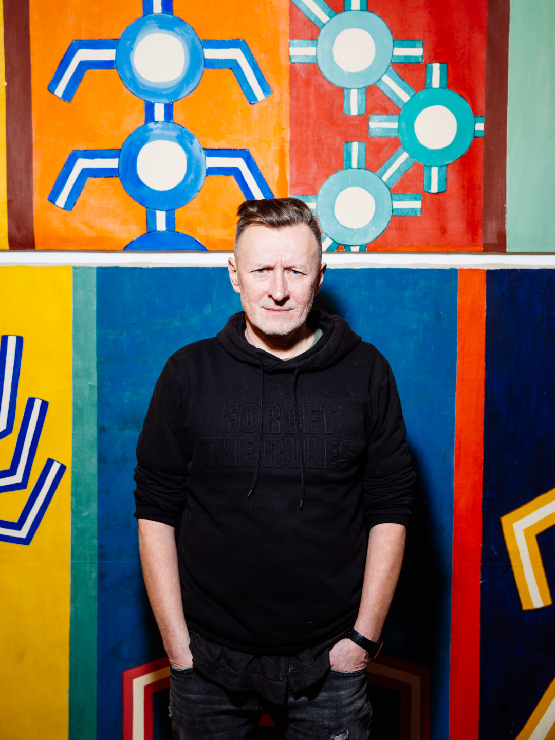 Художник Олег Маслов на фоне собственных работ 1990 года «Шива Будда» и «Собака» выставлялись на первом рейве в «Планетарии»