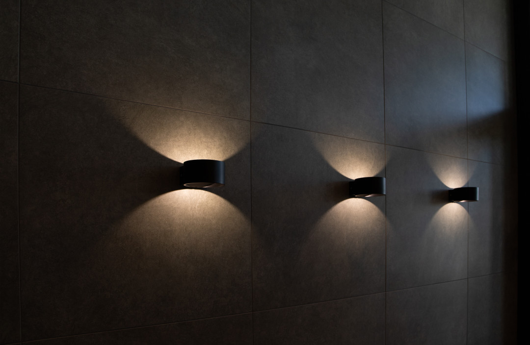 Коридор оформили керамогранитом Kerama Marazzi, чью фактуру подчеркнули с помощью декоративного освещения.