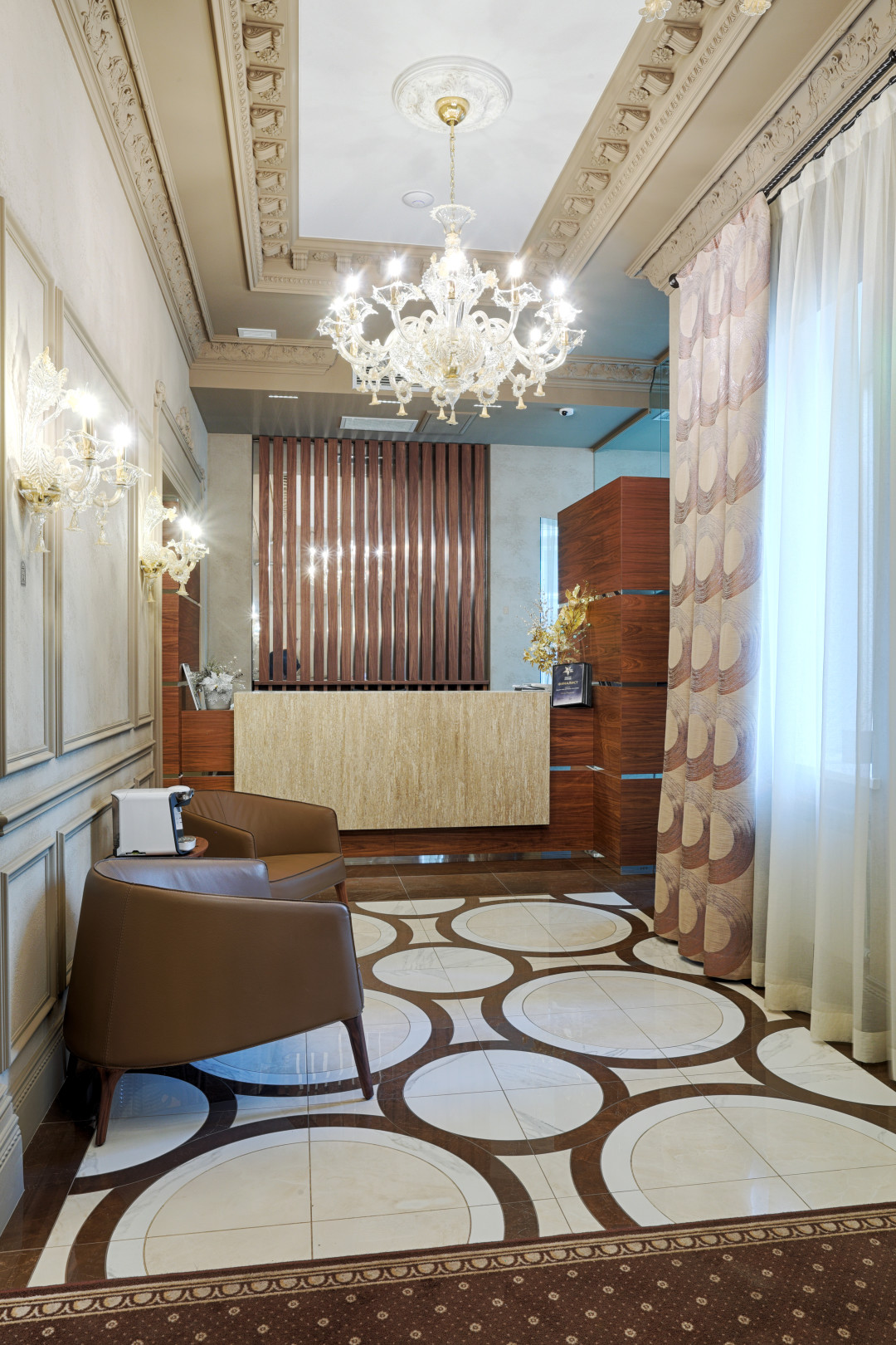 Благородство зоны ресепшн подчеркивает керамогранит Mirage из коллекции Jewels (Artlab Design). А стойка из акрилового камня Hanex надолго сохранит