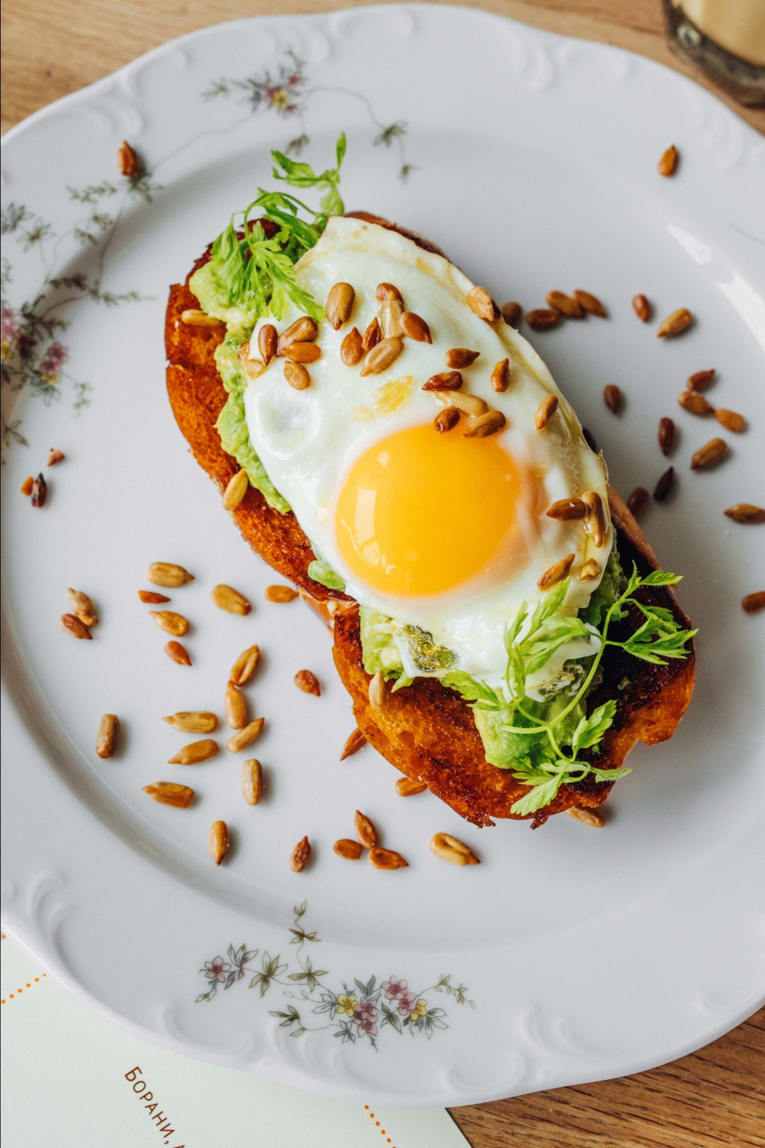 Глазунья на авокадо и воздушной булочке хала с миксом из жареных семечек