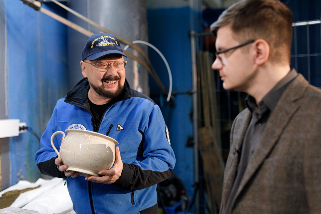 Андрей Лукошков показывает Игорю Топоркову находки с «Посудника»