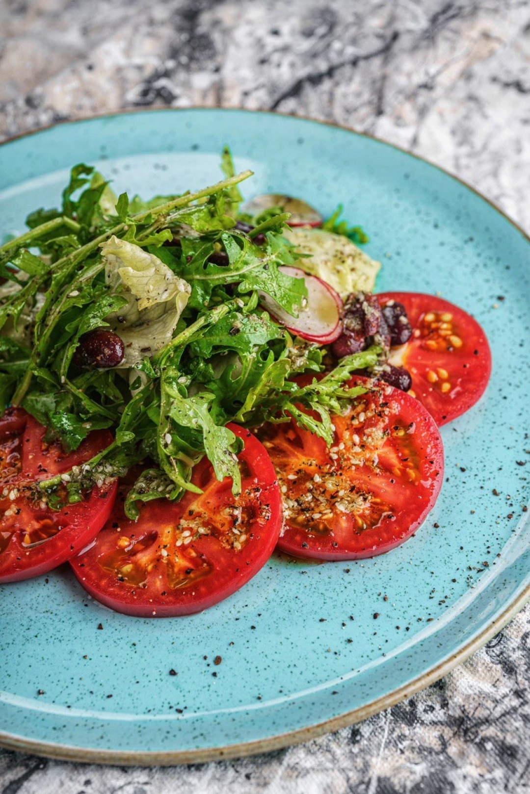 Руккола с помидорами, фасолью, вялеными томатами и соусом на основе кунжута