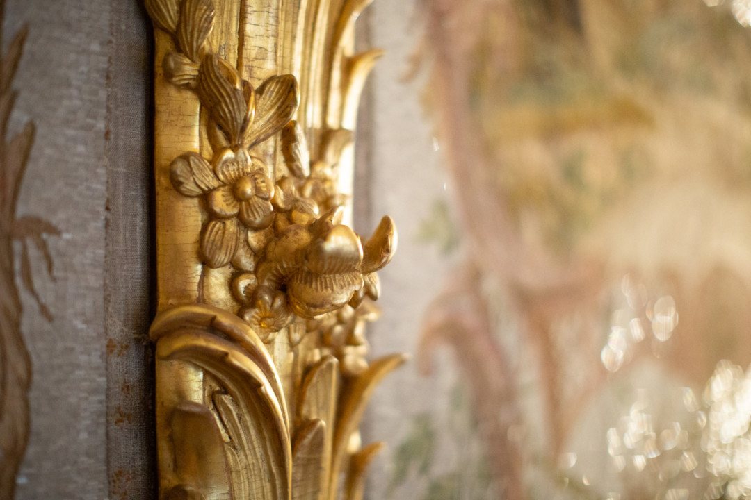 Панно заключены в рамы с золоченой резьбой, имитирующей стволы деревьев, увитых листьями, цветами и гроздьями винограда