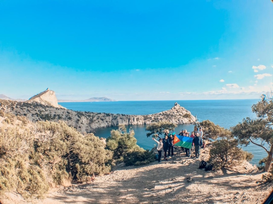 Подданные Королевства Северный Бархант демонстрируют флаг на морском побережье в Крыму.