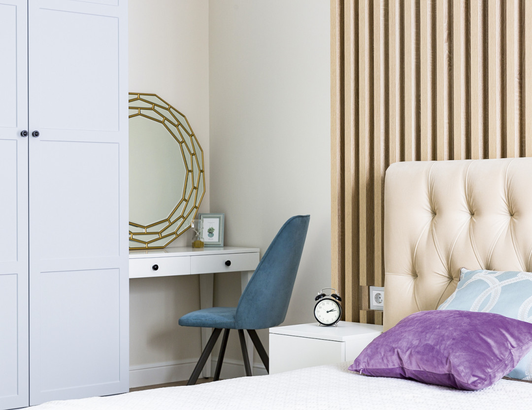 Стена за кроватью отделана деревянными рейками: такое решение подчеркивает натуральность интерьера