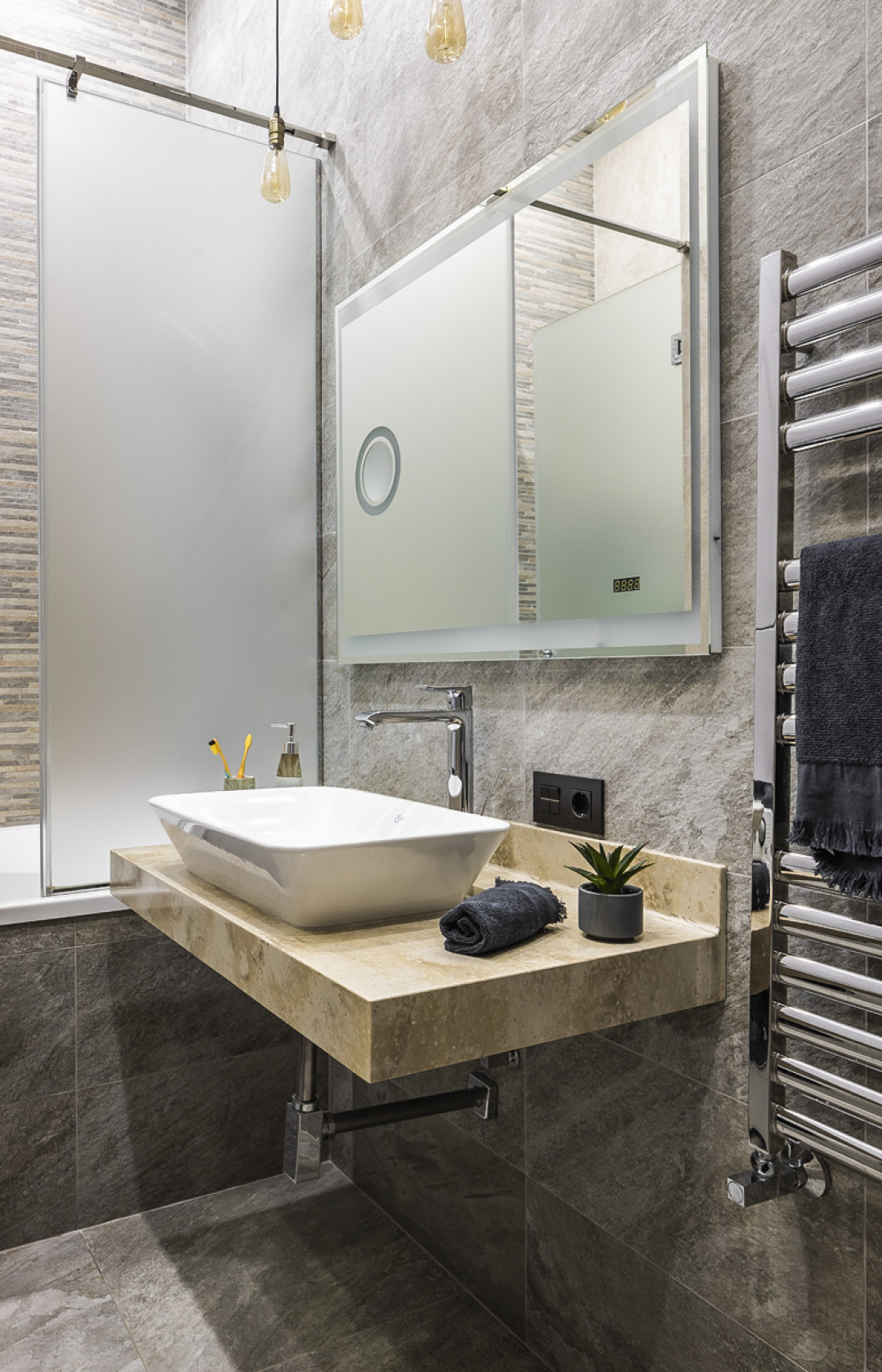 Для оформления санузла использован грубый керамогранит, имитирующий камень