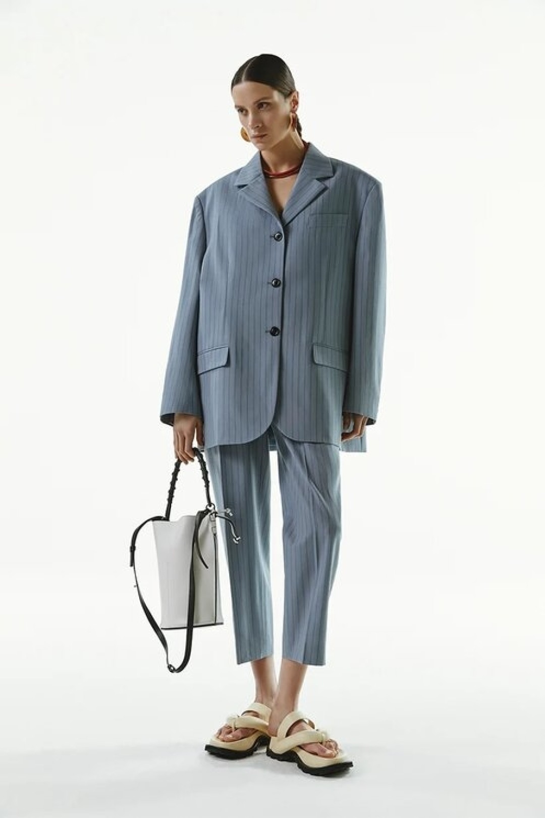 Жакет Aсne Studios, 73 600 руб., брюки Aсne Studios, 39 950 руб., сумка Loewe, 148 500 руб., сандалии Jil Sander, 58 250 руб., серьги Jil Sander, 31