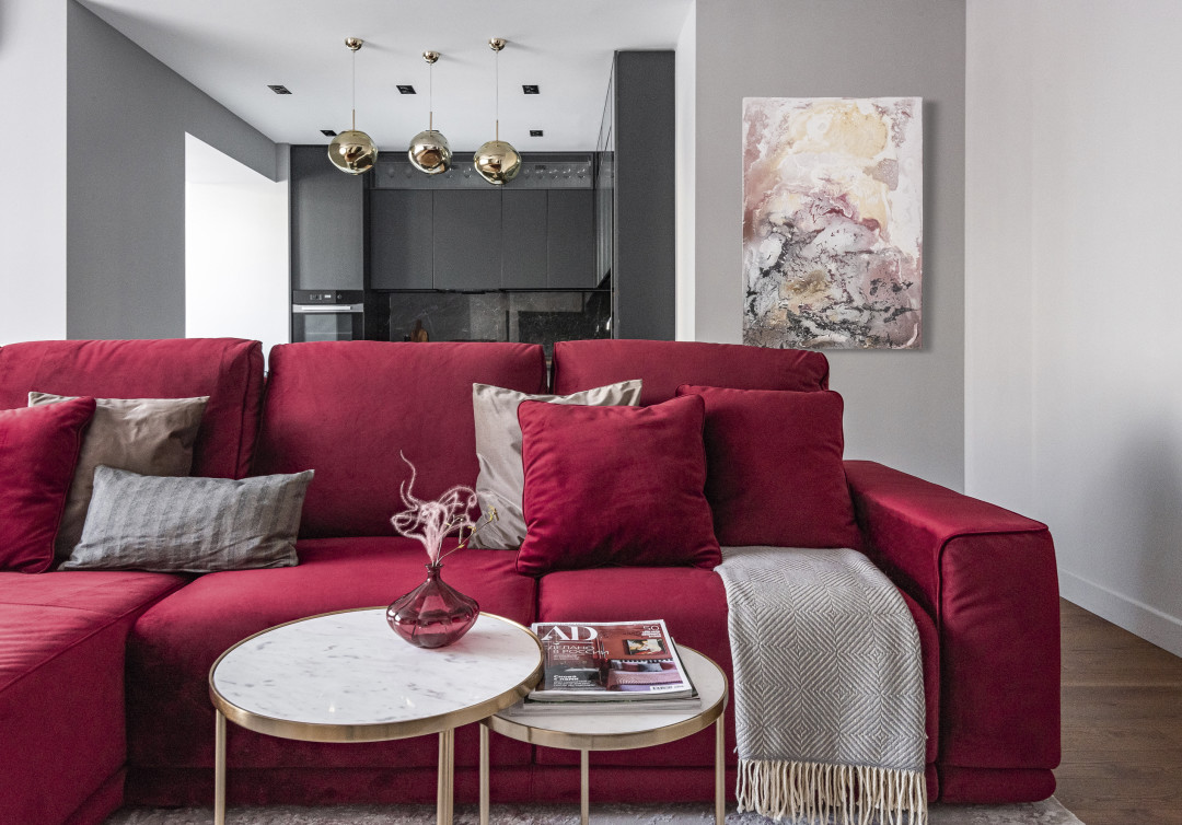 Круглый кофейный столик в гостиной перекликается по форме с латунными кольцевыми светильниками