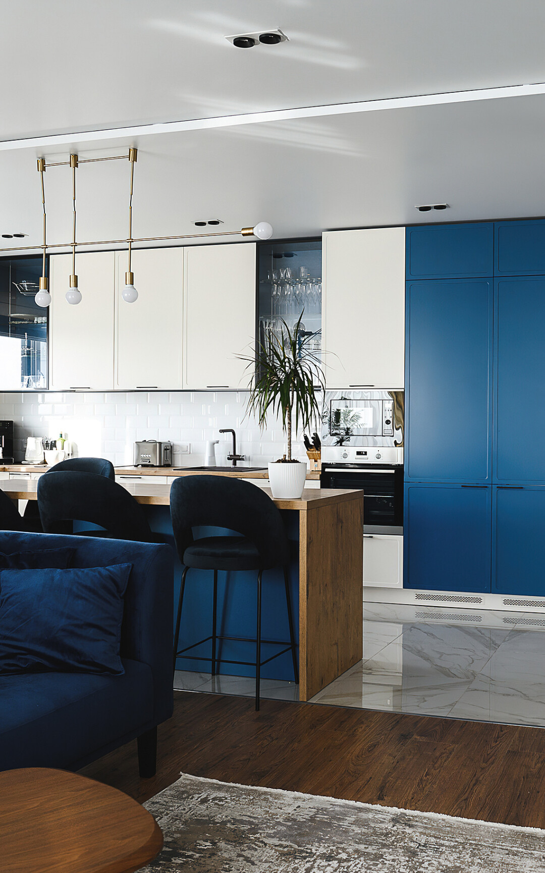 Для пола на кухне использовали глянцевую керамическую плитку с имитацией под мрамор. Такой подход помог визуально зонировать пространство.