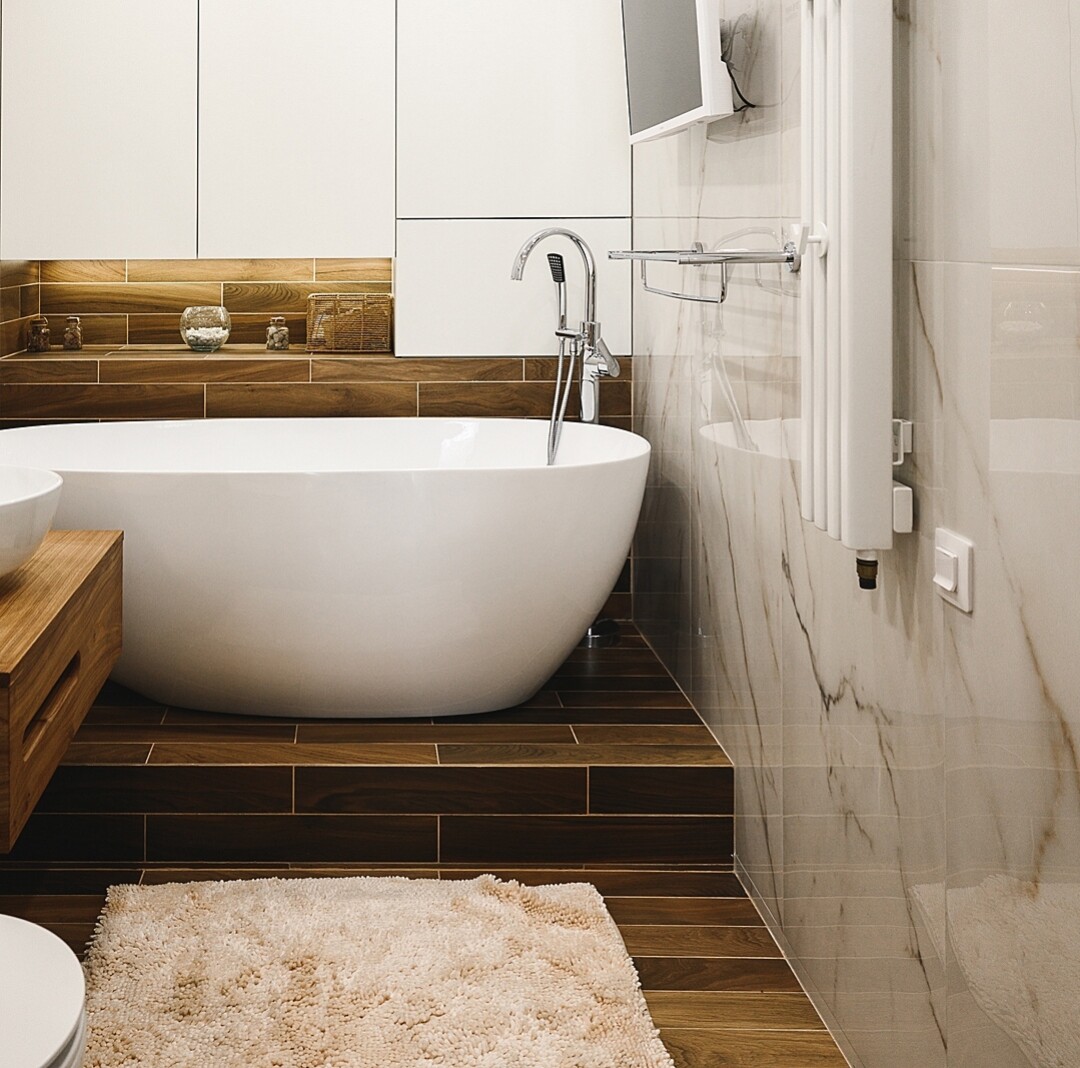 Главной героиней ванной комнаты стала белоснежная ванна-чаша, которая особенно эффектно смотрится на фоне стены, имитирующей массив дерева.