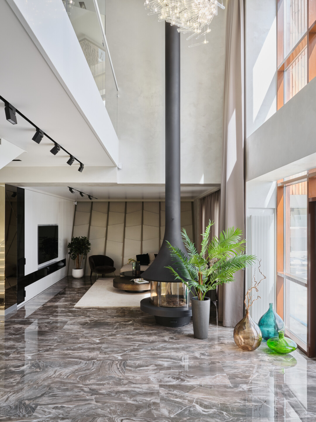 В гостиной плотный серый бельгийский сатин поддерживает глянцевый пол и серые оттенки в зале. Тюль тоже серый, с волнистой структурой, объемный