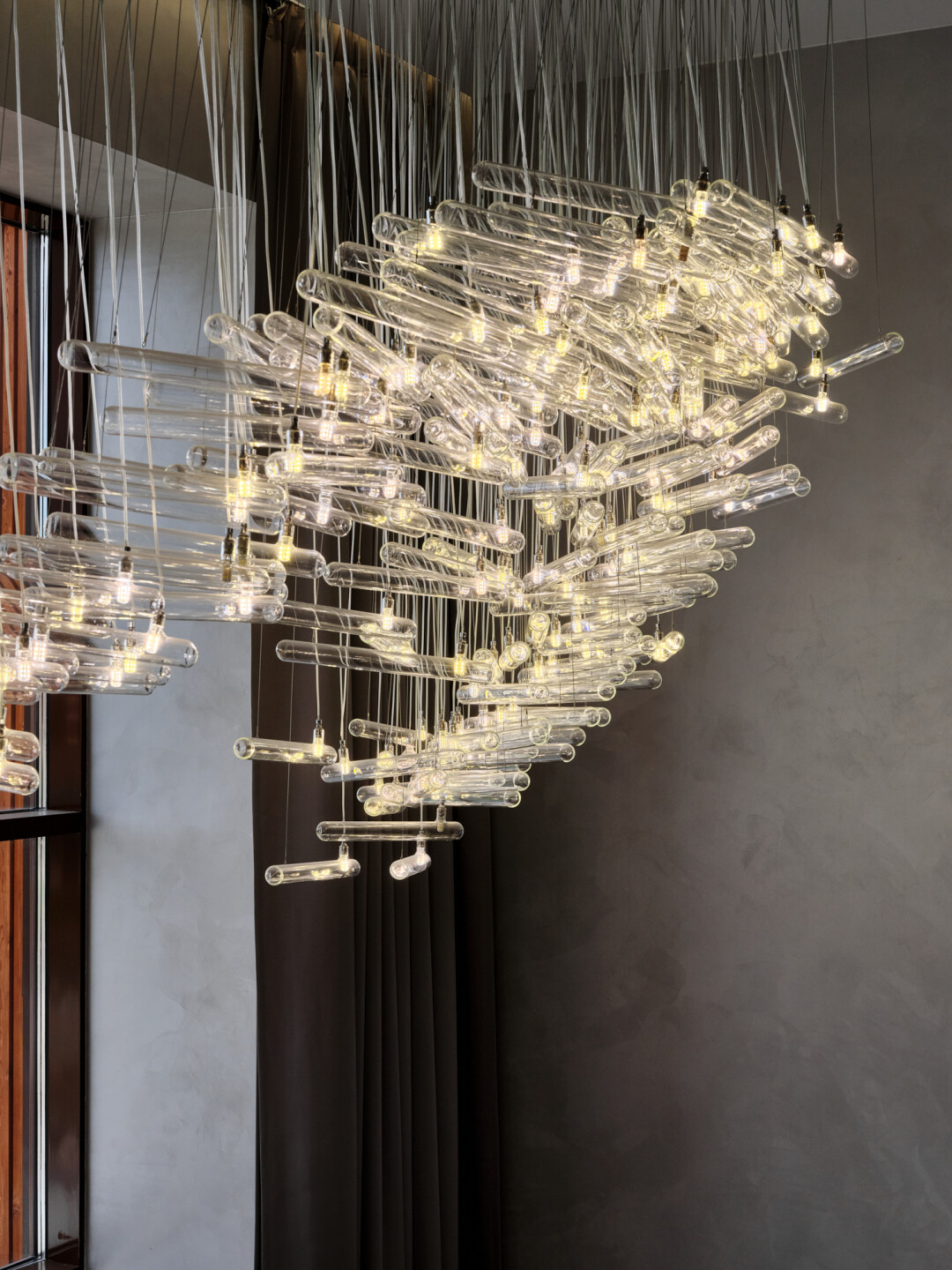 Серию необычных люстр в доме возглавляет завораживающая группа из 300 (трехсот) подвесов, «парящая» на высоте шести метров: сквозь прозрачные элементы