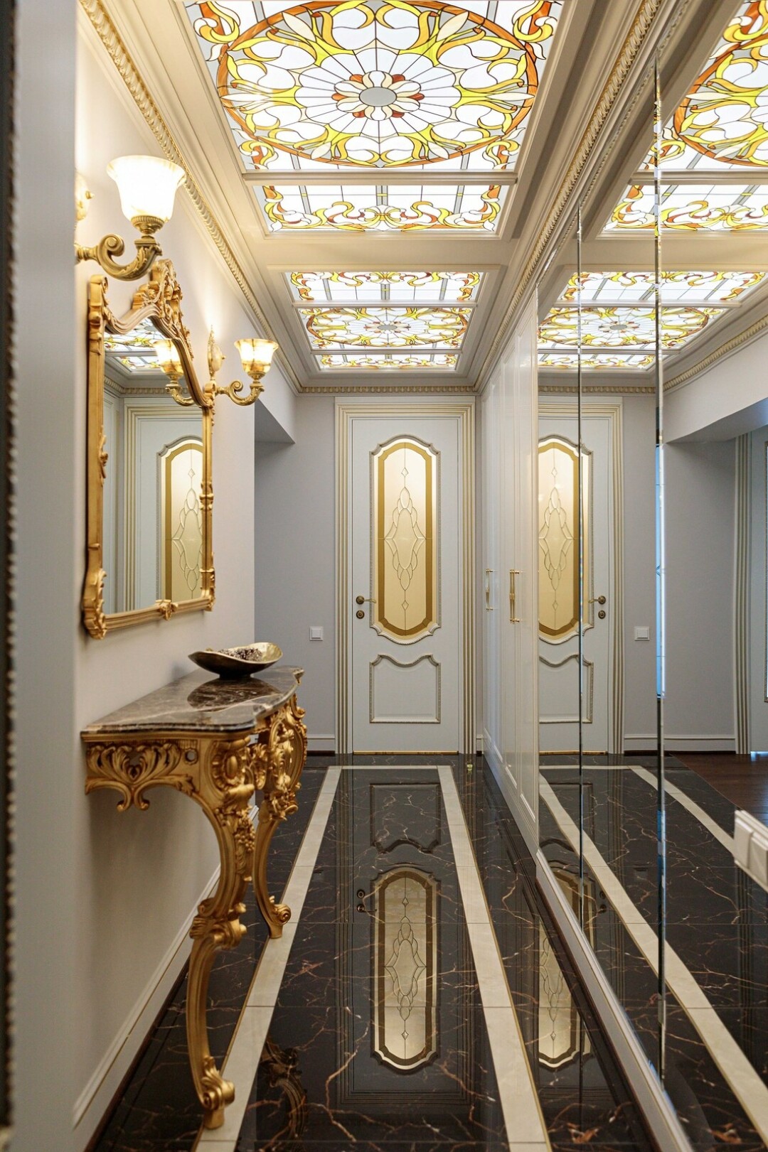 Раздвигают пространство большие зеркала, а мягкий рассеянный свет подчеркивает витражный узор потолка