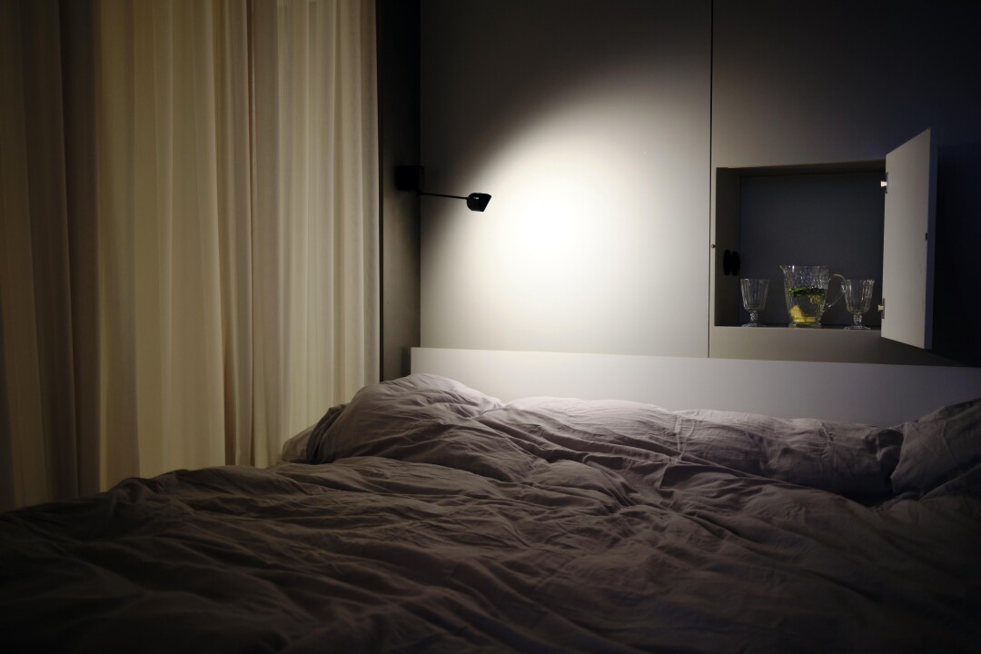 Родительская спальня хитроумно спрятана за раздвижной деревянной панелью, что обеспечивает необходимую при троих детях приватность