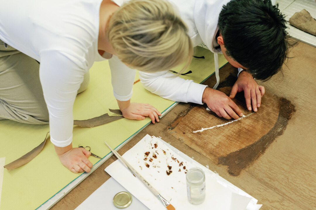 Опытные специалисты учили начинающих реставраторов удалять старые заплаты и ликвидировать прорывы полотна