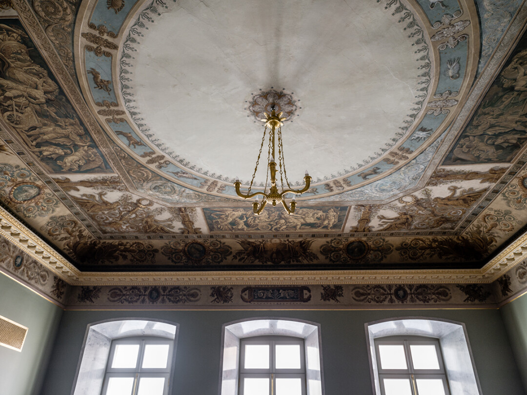 В центре плафона изображены знаки Зодиака, на падуге и фризе — доспехи, знамена, венки, геометр