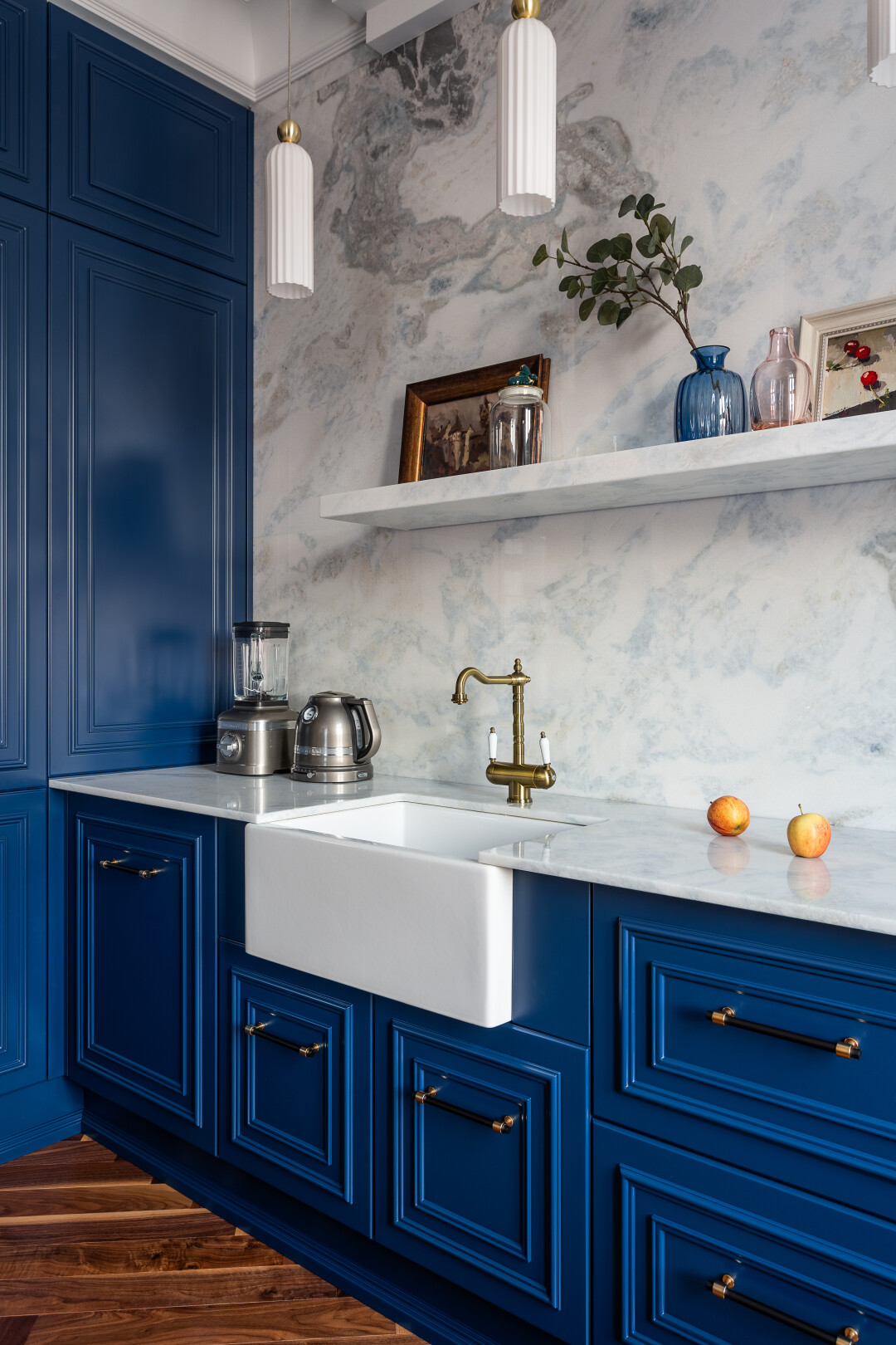 Выразительный кухонный гарнитур с фрезерованными фасадами глубокого синего цвета и качественной фурнитурой играет ведущую роль в интерьере кухни