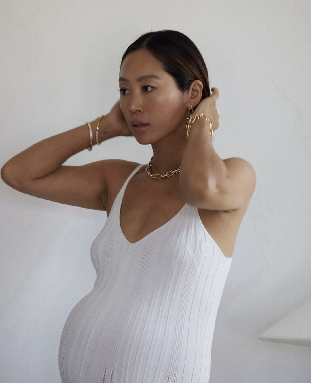 Эйми Сонг стилизует золотые аксессуары с лаконичным трикотажным платьем
