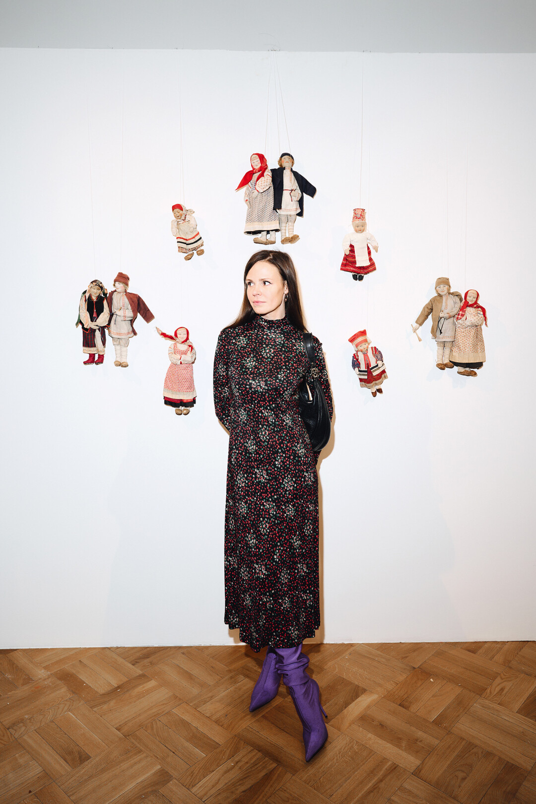 Продюсер и соавтор ДК «Исток» Юлия Журавлева на фоне кукол 1920-х годов, представляющих костюмы народов СССР
