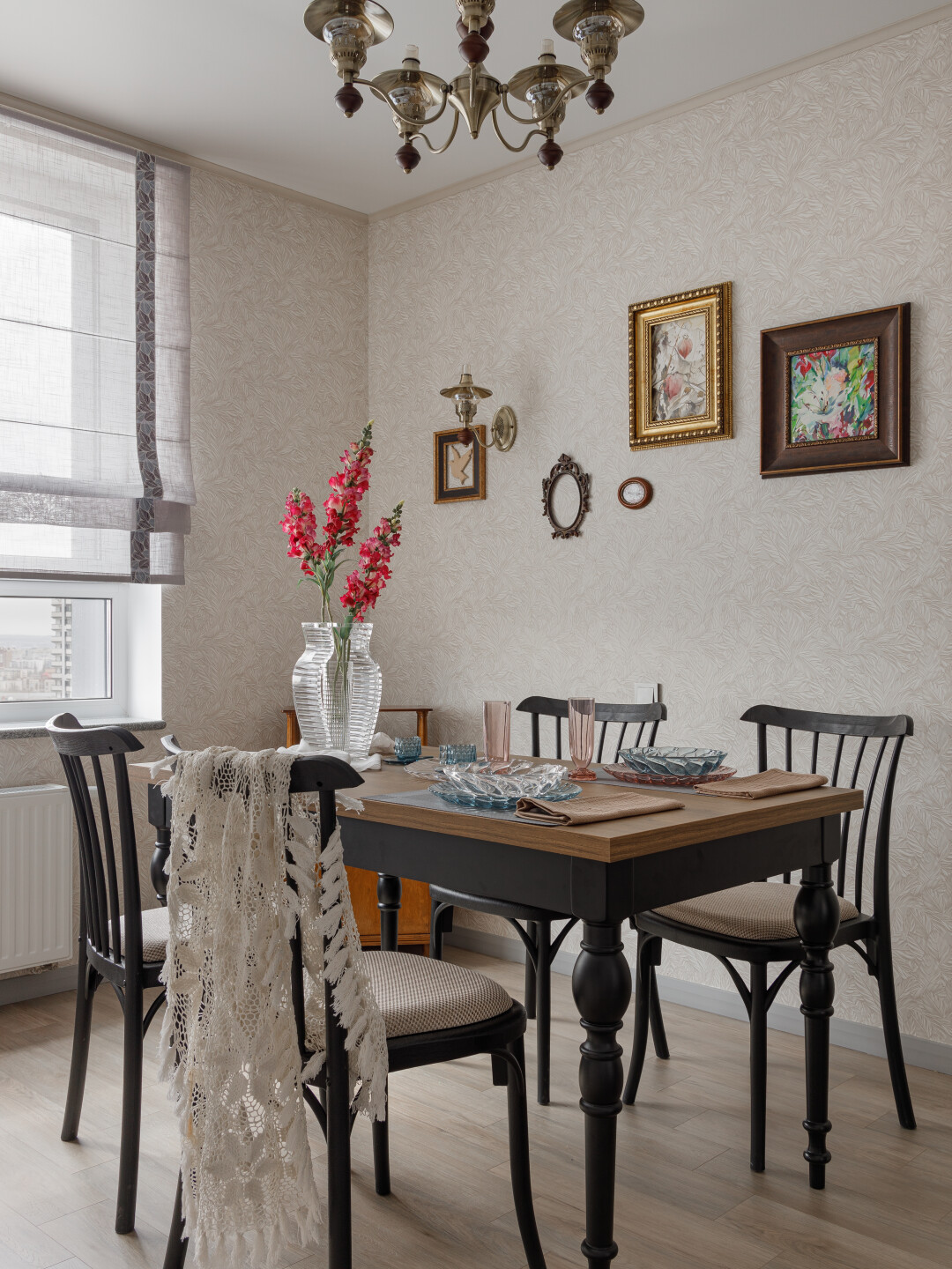 Люстру и бра отлично поддержала обеденная группа стола с черными ножками и стулья от студии Enza Home.