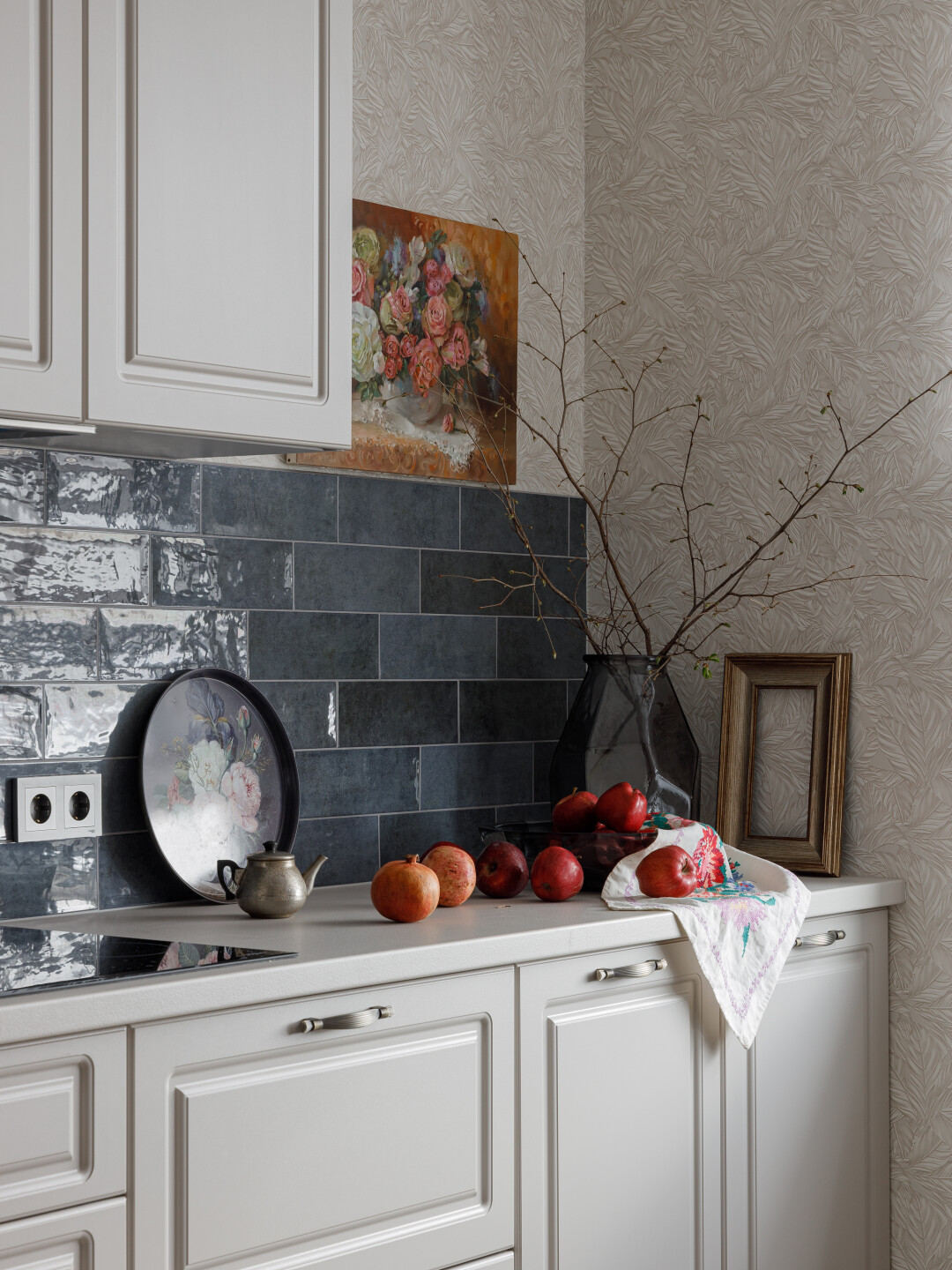 Кухня в серо-бежевых тонах с яркими акцентами в виде картин и активного фартука цвета индиго над рабочей поверхностью.