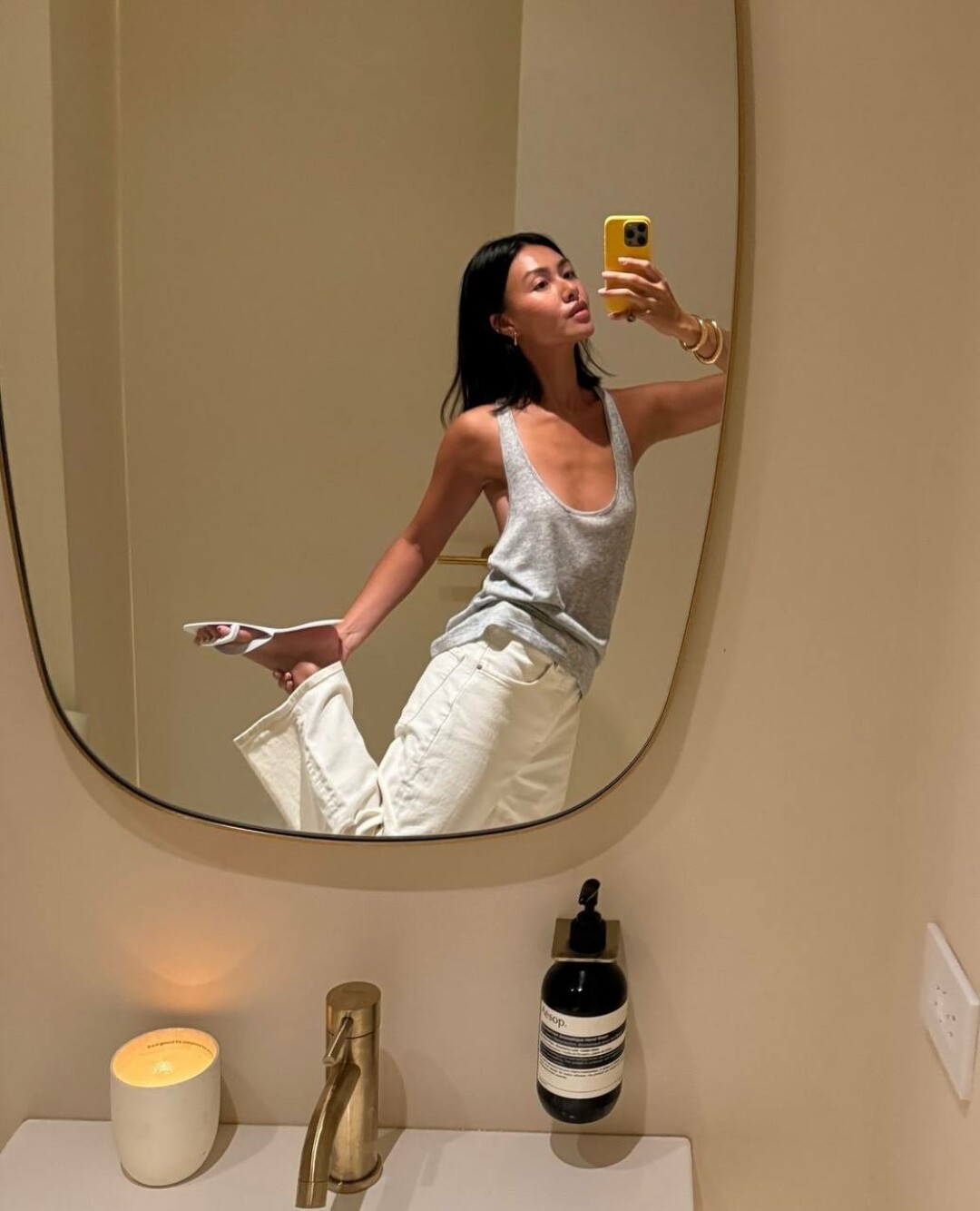 Мими Нгуен женит два крупных браслета и носит их с лаконичными джинами и майкой