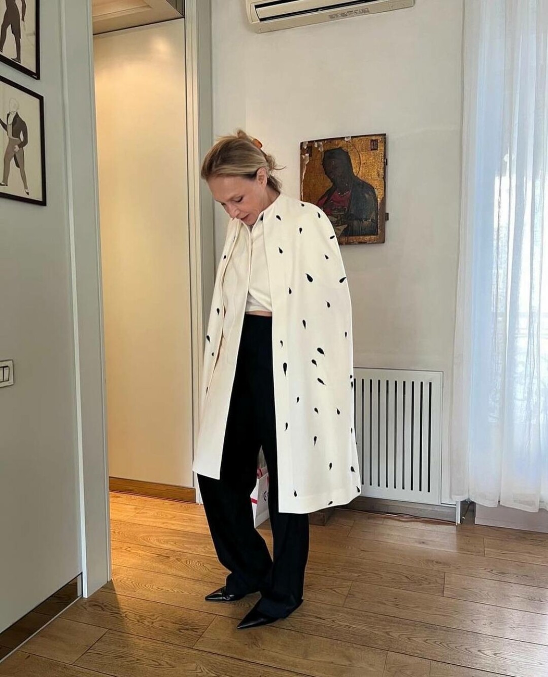 Алена Долецкая миксует псевдогорностаевый кейп Cloche с укороченной белой футболкой, костюмными брюками и остроносыми ботильонами