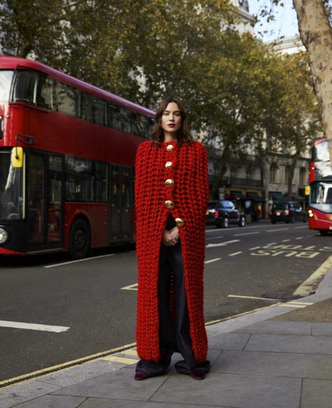 Фэшн-редактор Алекса Чанг выбирает насыщенно-алый вязаный кейп — носит его в качестве топа с oversize-джинсами и замшевыми лоферами