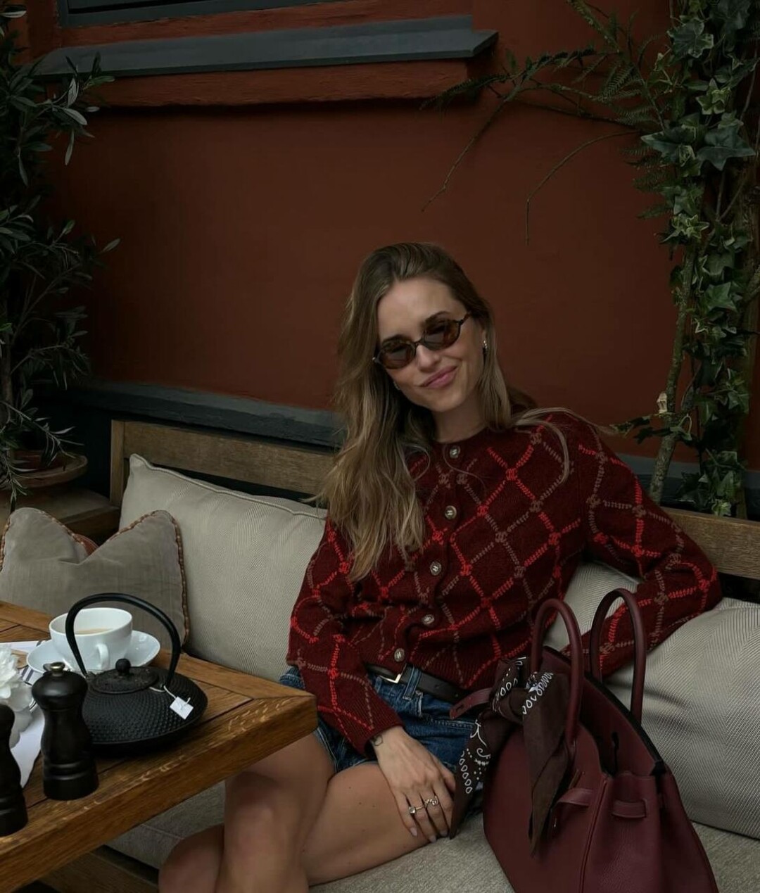 Перниль Тейсбек мэтчит бордовый кардиган с Birkin в тон (и повязывает на ручку шоколадную бандану)