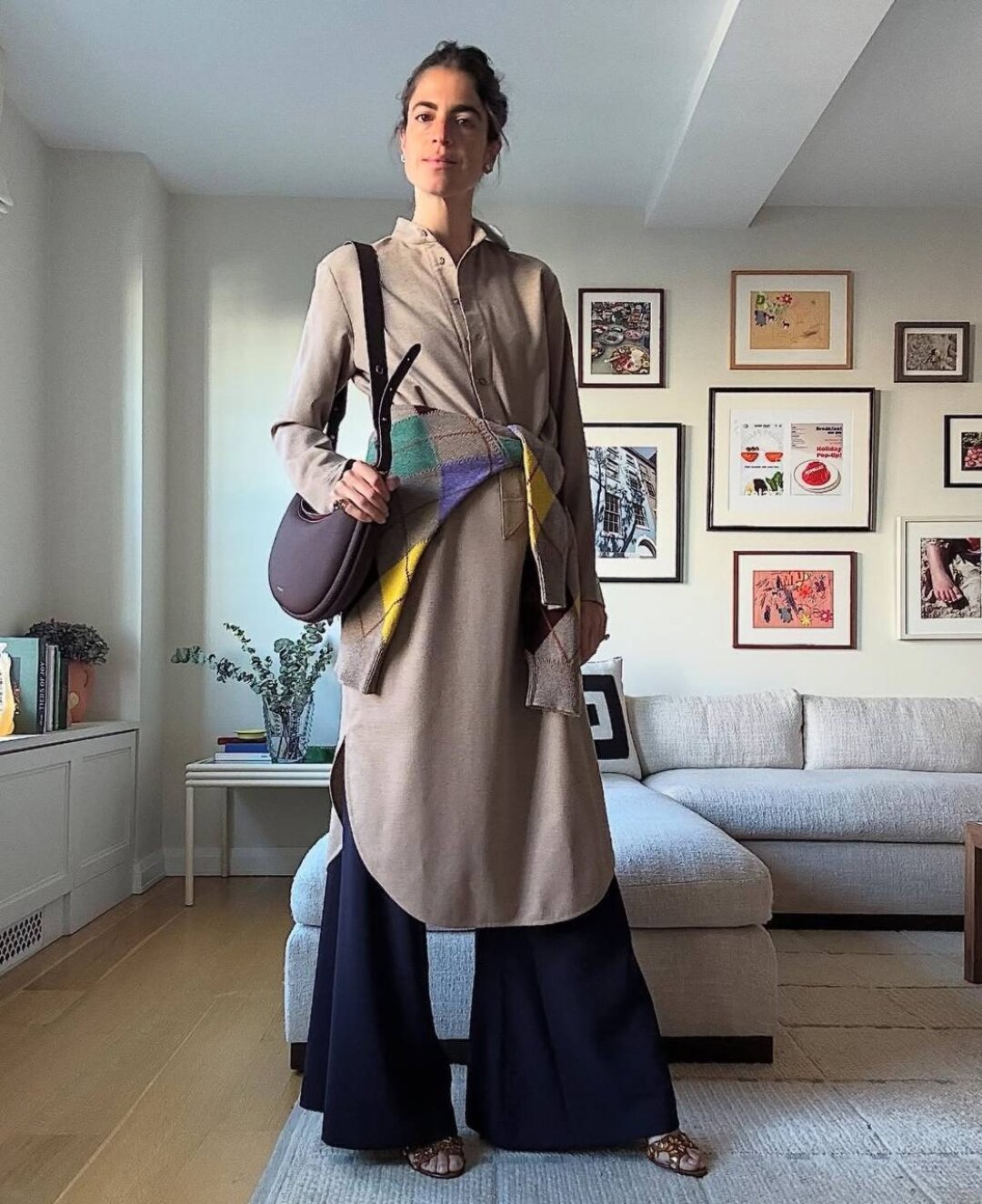 Леандра Медин повязывает разноцветный аргайл-джемпер поверх удлиненной песочной рубашки (стайлинг-трюк для базовых комбо)