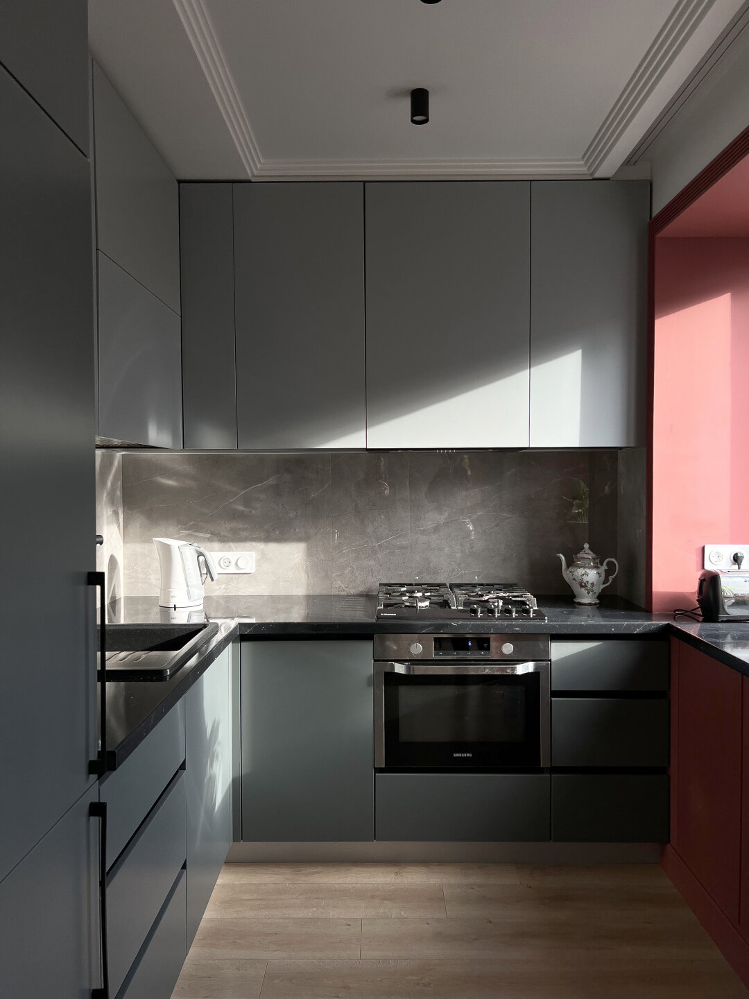 Пространство кухни обретает новую геометрию: рабочая поверхность элегантно перетекает в зону подоконника, создавая визуально завершенную и максимально