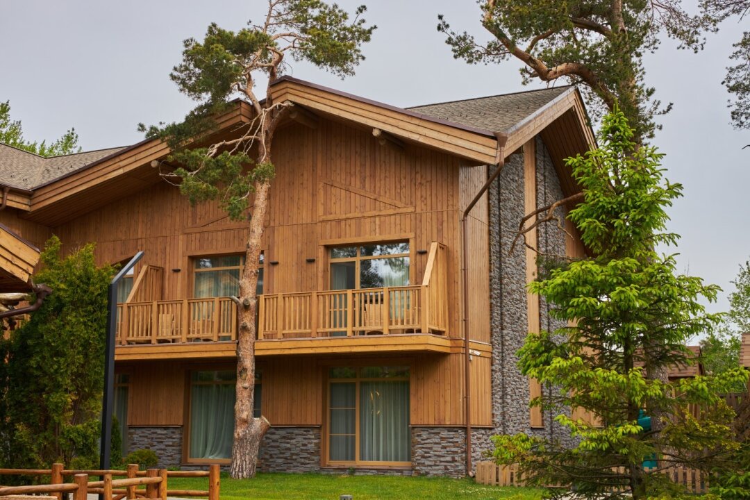 В отделке преобладают натуральные материалы, теплый свет — а сосны за окном становятся продолжением интерьера