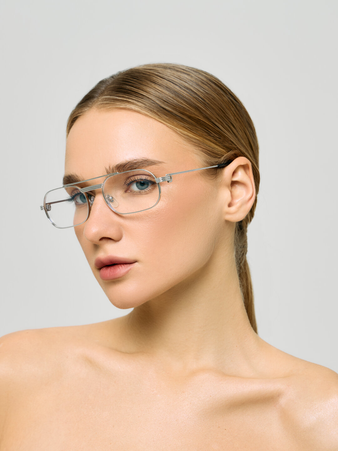 Ошибка: овальная форма оправы не соответствует графичной нижней трети лица, визуально ломает его геометрию.