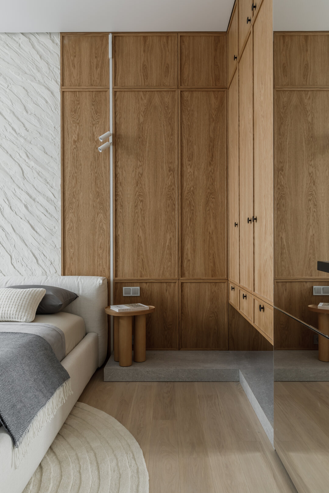 Вместо одной центральной люстры — сложная система освещения: верхний свет нужен для подсветки акцентной стены, а направленная лампа — для работы за