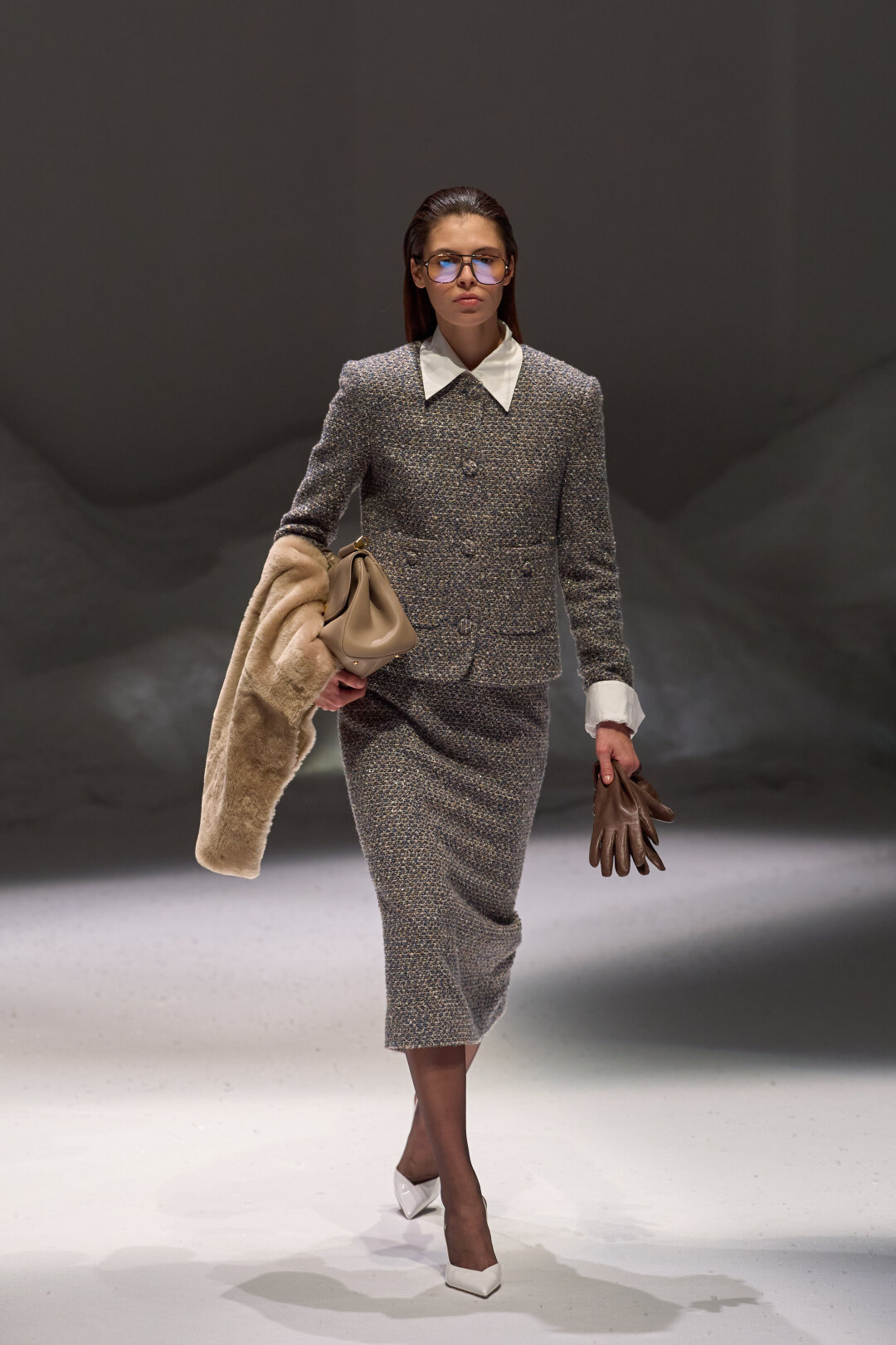 В одной руке держим меховой шарф-снуд Toteme и сумку Dolce & Gabbana, в другой — кожаные олдмани-перчатки Kiton