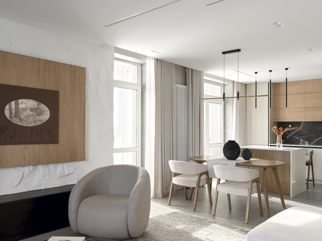 Мягкие формы кресла и стульев входят в диалог с четкой геометрией кухни