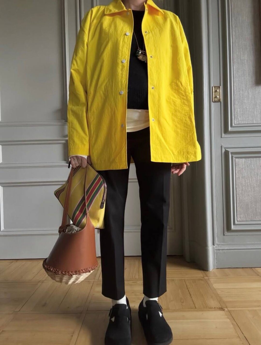 Бланка Миро носит канареечную ветровку в качестве цветового акцента в черно-белом образе