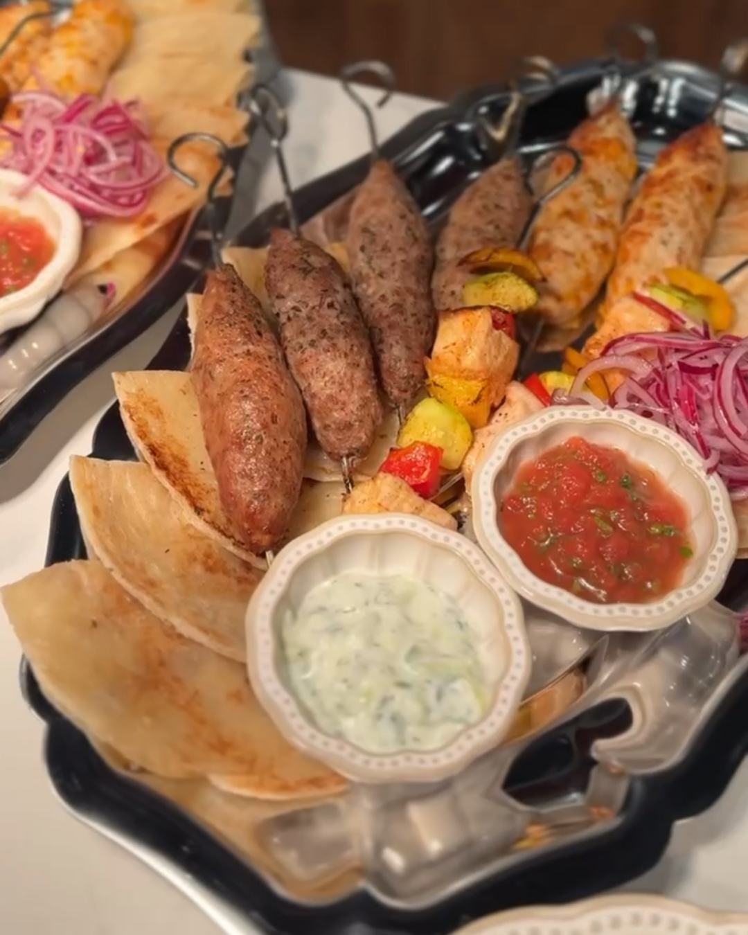 Кебаб и овощи на гриле с лепешкой роти и соусами дзадзики и сальса в ресторане Nomades